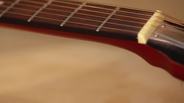 A resonator/national-steel guitar lying on a table in the sunlight. Camera rolls along from the head backwards on a slider