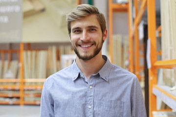 portrait of a smiling young warehouse worker working in a cash and carry wholesale store.