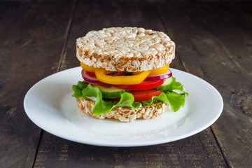 homemade healthy vegetarian sandwiches  rice  cakes with tomatoe lettuce bell pepper cucumber red onion on plate close up