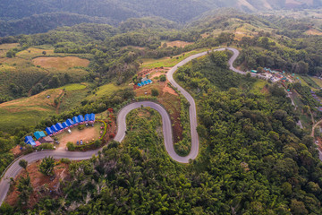 Drone Aerial view of Beautiful roads suitable for holiday driving. The winding mountain road and beautiful nature at sunset time and winter weather in northern of Thailand.