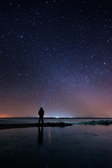 Lonely man at the beach under the starry sky