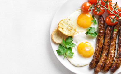 Fried eggs, sausages and cherry tomatoes
