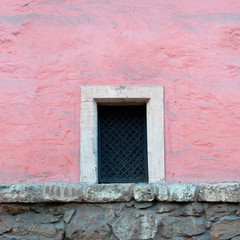 Window on an old pink stucco wall. Seamlees texture