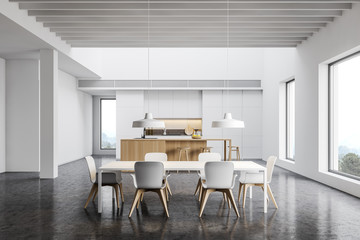 Spacious white kitchen with bar and dining table