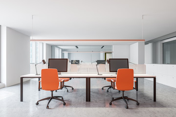 Modern office workplace with orange chairs