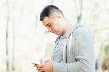 Portrait of young man looking at smartphone. Young man is using his smartphone