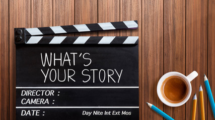 What's your story.text title on movie clapper board  and coffee cup on wooden background