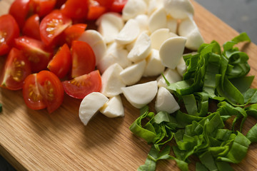 chopped ingredients for salad, mozzarella, spinach and cherry tomatoes