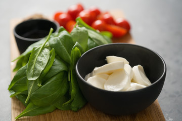 ingredients for salad, mozzarella, spinach and cherry tomatoes