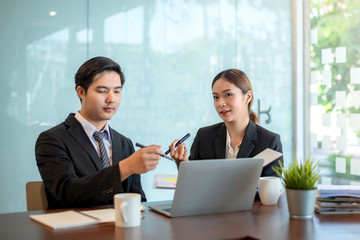 Modern business people discussing work in office and using laptop together while working.