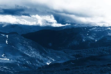 bergiges Gelände, Silhouetten von Bergen und dramatische Wolken. klassisches blaues Pantone 2020. Hintergrundbild. Platz für Text © Taranova_ksenya