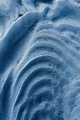 Sandmuster einer Strandnahaufnahme im Sommer. Klassische blaue Pantone-Farbe das Jahr 2020. vertikales Bild © Taranova_ksenya