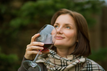 beautiful girl drinks red young wine from a glass