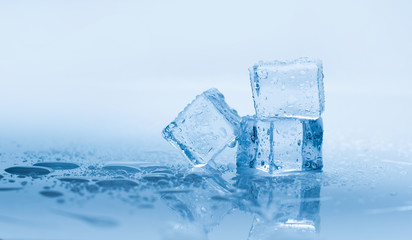 Naklejka na ściany i meble Ice cubes square with drops water clean on blue background