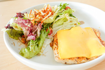 Grilled chicken steak with melted cheese and mixed salad