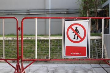 A sign strictly prohibiting this route. No entry sign hanging on iron fence.