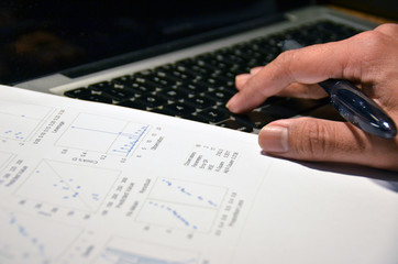 Typing on laptop and analysing statistics and data