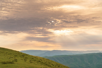 Cloudscape of sun rays shining down on alpine meadows
