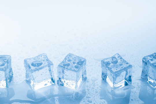 Ice cubes square with drops water clean on blue background