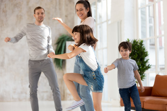 Happy loving family dancing to favorite song at home.