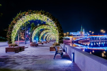 Moscow. Russia. Decorated embankment of the Moscow river. Zaryadye Park. Evening in Moscow. Decorative arches of plants and garlands. Kremlin embankment. Evening city lights.Decorations of the capital