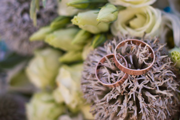 Close up view on wedding rings on rustic brides bouquet
