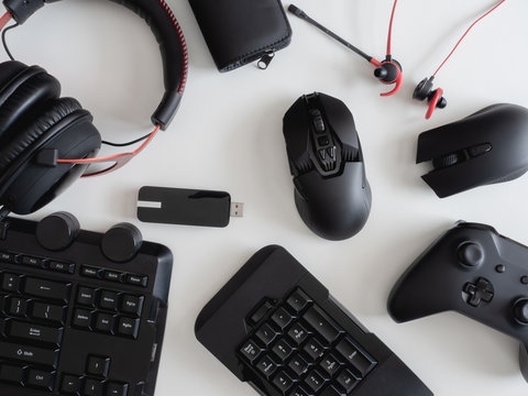 gamer work space concept, top view a gaming gear, mouse, keyboard, joystick and headset on white table background.