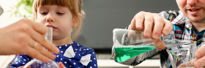 Man and little girl play with colourful liquids