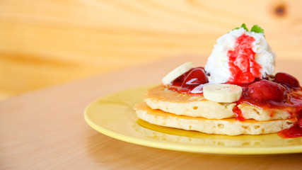 Buttermilk pancake filled with sliced banana and strawberries