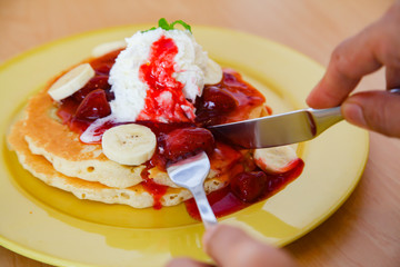 Buttermilk pancake filled with sliced banana and strawberries