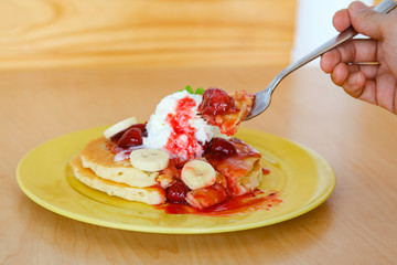 Buttermilk pancake filled with sliced banana and strawberries