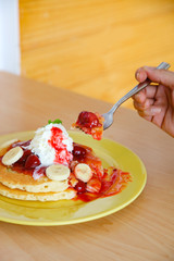 Buttermilk pancake filled with sliced banana and strawberries