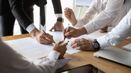Diverse businesspeople discuss financial paperwork at office briefing