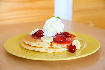 Buttermilk pancake filled with sliced banana and strawberries