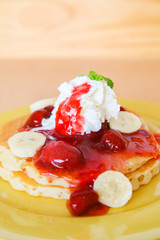 Buttermilk pancake filled with sliced banana and strawberries