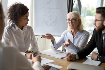 Multiethnic colleagues brainstorm discussing business ideas at meeting