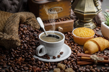 Coffee in a cup on a background of coffee beans, on an old background.