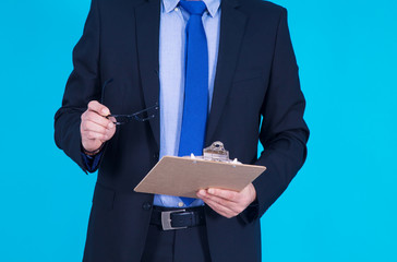 businessman with glasses in one hand and reports in the other