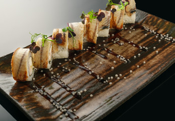 Roll with eel and shrimp on a black background