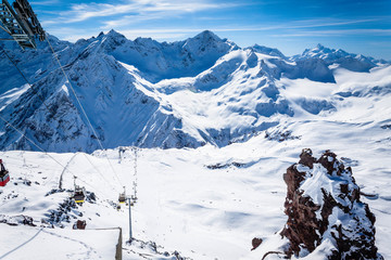 Winter panoramic view of the snowy high mountains of Elbrus and cableway with funicular in the Russia