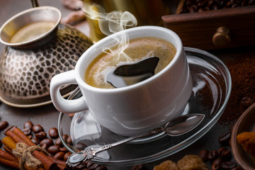 Coffee in a cup and saucer on an old background.