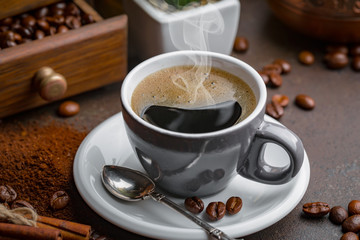 Coffee beans are roasted in a pan with smoke.