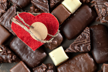 Appetizing food background. Assortment of chocolate handmade candy and red heart card for valentine's day. Chocolate background. 
