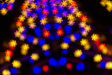 Fototapeta na wymiar Bright multicolored snowflakes bokeh background. Happy new year