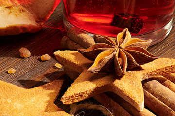 Christmas mulled wine or gluhwein with spices, cookies and orange slices on rustic table, traditional drink on winter holiday, christmas lights and decorations