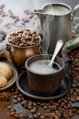 Coffee in a cup on a background of coffee beans, on an old background.