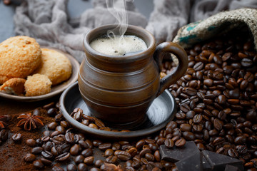 Coffee in a cup on a background of coffee beans, on an old background.
