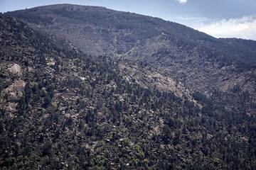 Panoramic of some mountains under a cloudy blue sky