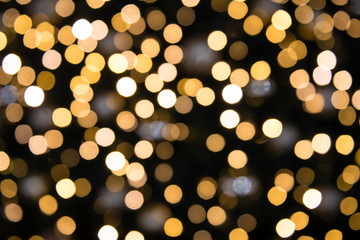 Dark abstract blurry background with golden bokeh circles of light