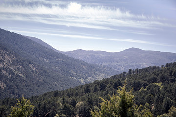 Fototapeta premium Panoramic of some mountains under a cloudy blue sky